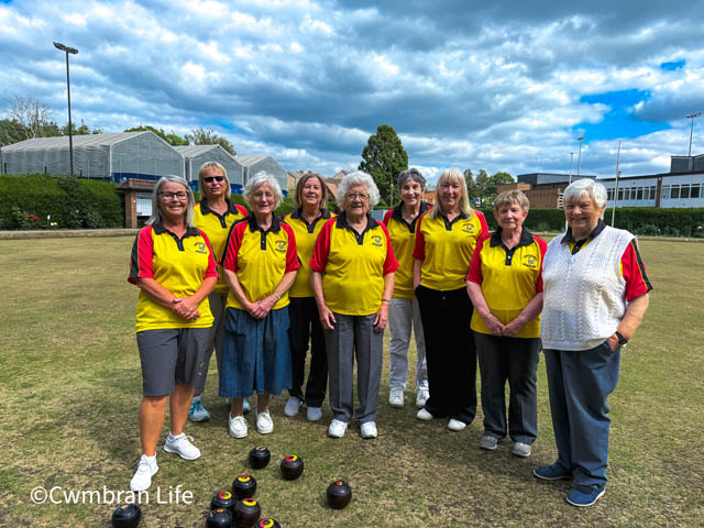 a group of female bowlers on the green