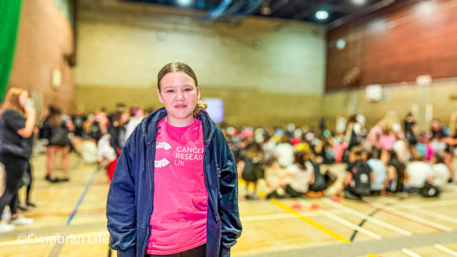 a teenage girl wearing a pink cancer research UK t-shirt