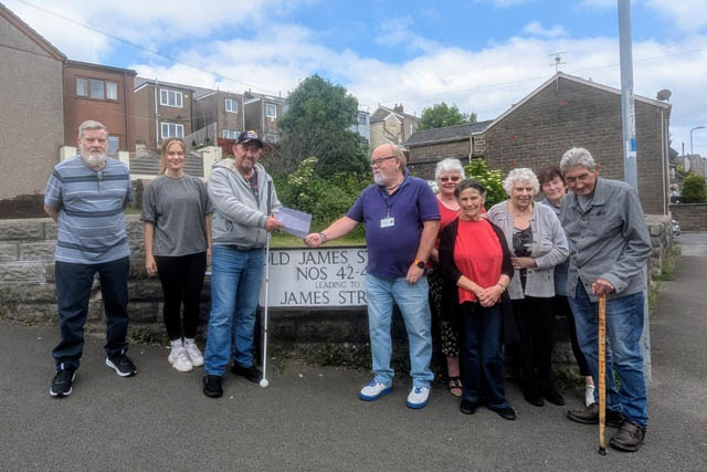 a group of residents hand a petition to a councillor
