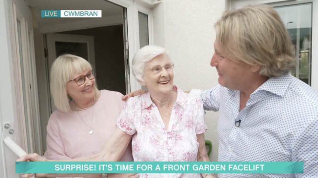 two women and a man by a front door