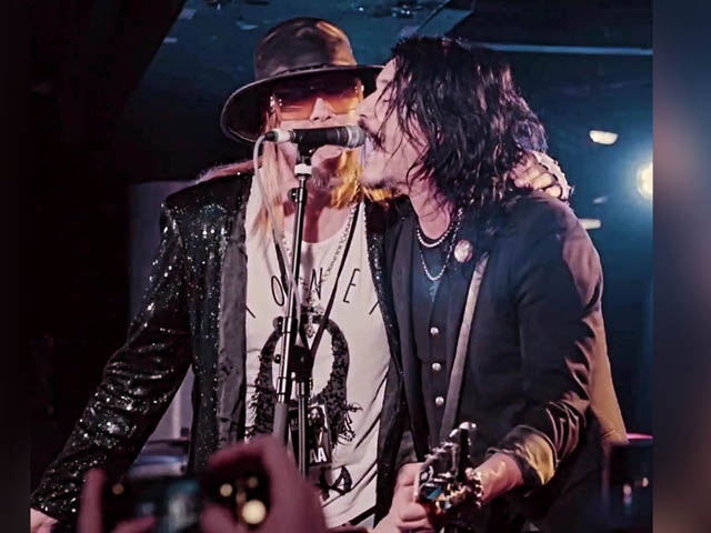 Gavin Fevlus and Gilby Clarke on stage together singing in same microphone
