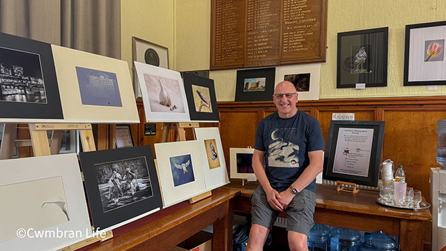 Kevin Morgan, from Cwmbran Photographic Society, in the room surrounded by photos on the walls