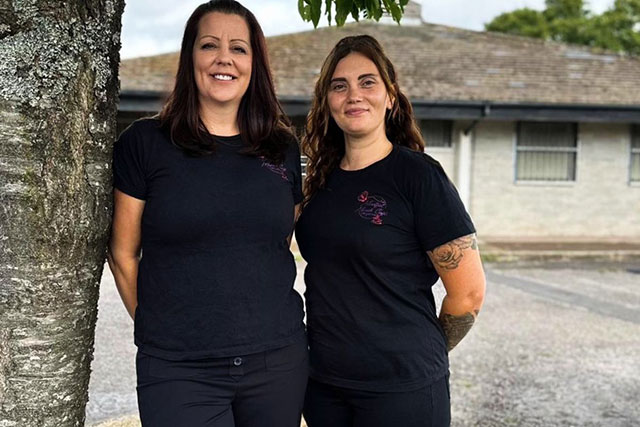 two women stood by a tree