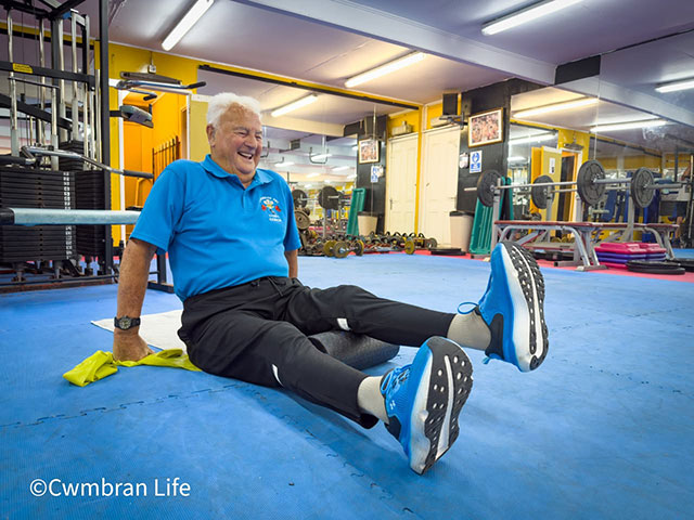 boxing coach Keith Jefferies sat on a blue mats in his boxing gym