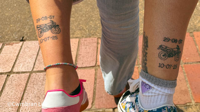 two legs, each with a motorbike tattoo on them