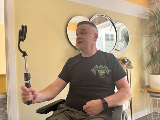 a man in wheelchair talking to a camera