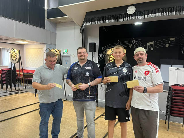four men stood in front of a darts board