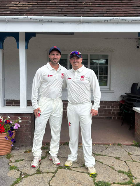 two male cricket players in their whites before a match