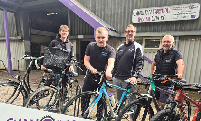 four men stood by bicycles