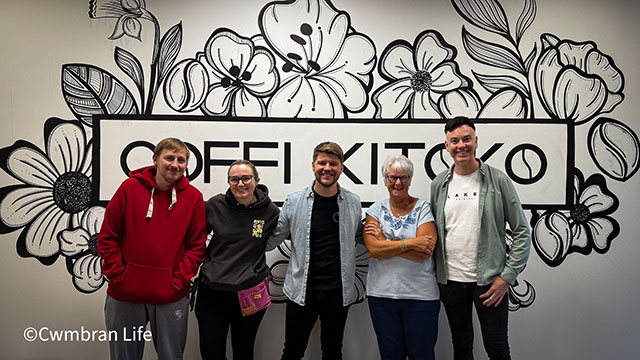 five people stood in front of a sign that says Coffi Kitoko