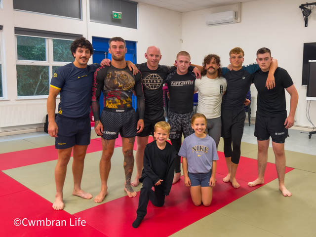 member of a martial arts class stood on mats at a class
