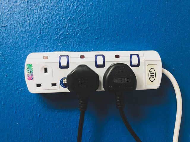 Blue wall with electric sockets and plugs