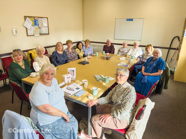 a group of 13 women sat around a table