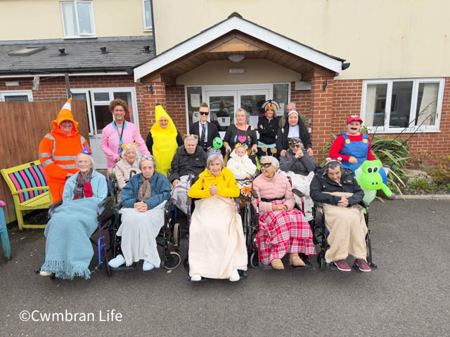 a group of people, nine in wheelchairs, with most dressed in fancy dress costumes
