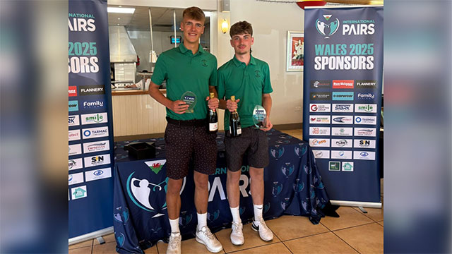 two male golfers hold trophies