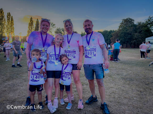 a group of adults and children holding medals after a race