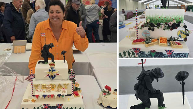 a woman stood in front of a cake with the words VE Day on it