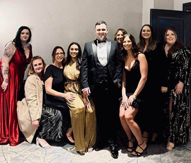 a group of men and women have a photo at an awards night