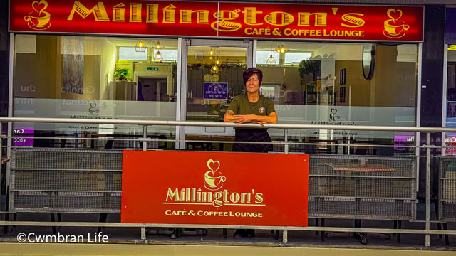 a woman stood outside a cafe called Millington's Cafe
