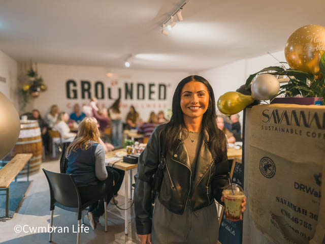 a woman holds a drink in a cafe
