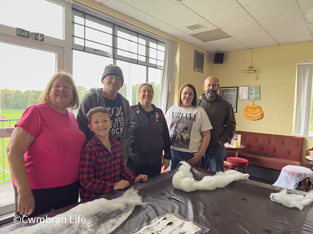 a group of people stood by a pool table