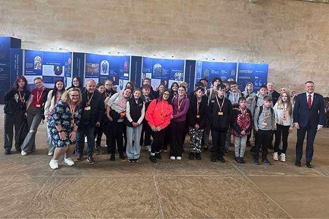 a group of young people with some adults in a large room