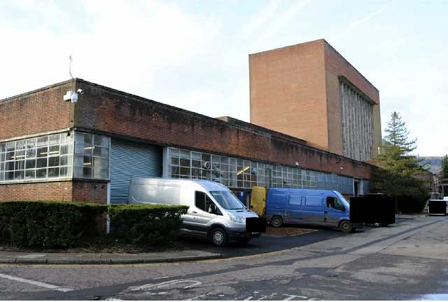 a warehouse with some vans parked in front of it