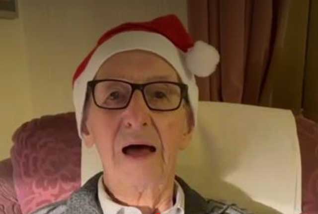 a 106 year old man with a santa hat on