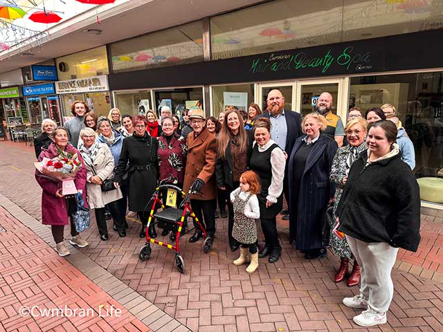 A group of adults and children outside a shop
