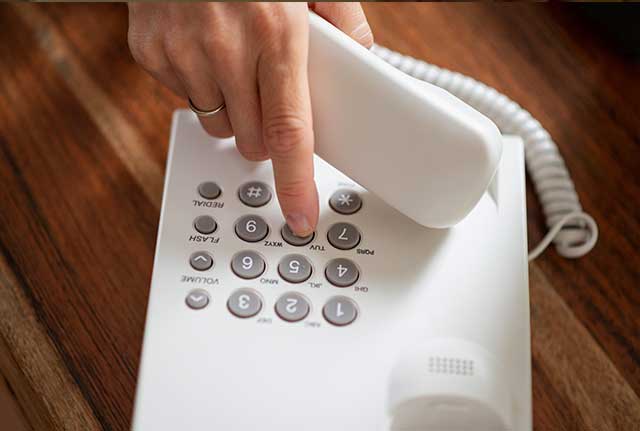 a hand pressing buttons on a phone