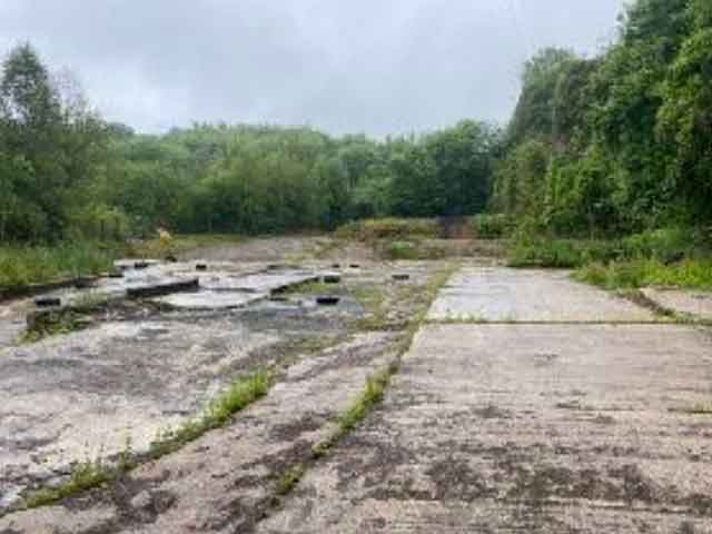 a large area of concreted land surrounded by trees
