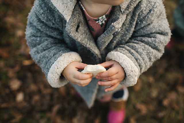 Baby girl holding piece of bread
