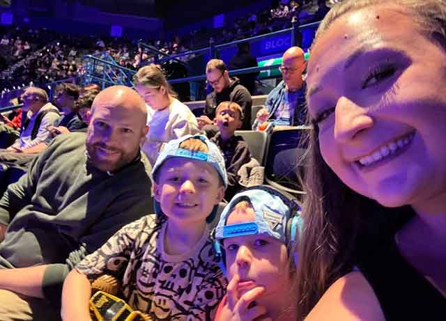 a mum and dad in the cinema with their two young sons