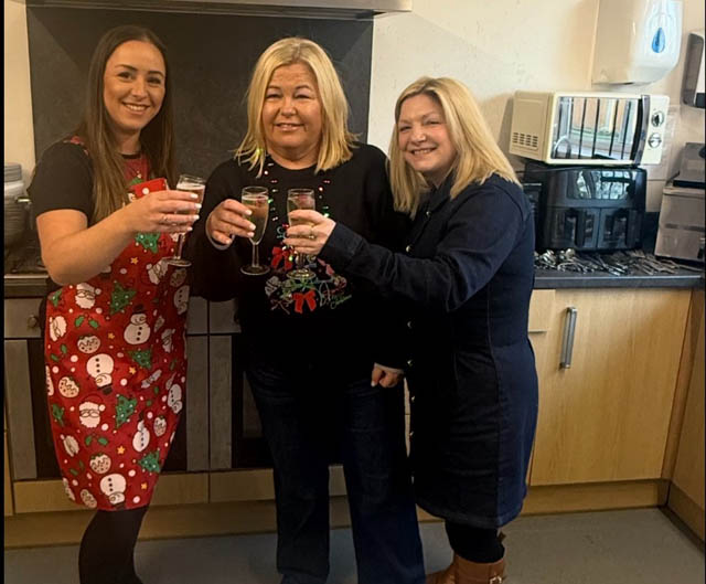 three women in a kitchen holding glasses of champagne