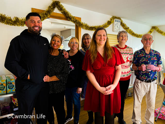 a group of seven men and women stood by door to a kitchen