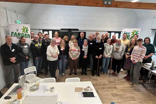 a large group of people in a hall smile at the camera