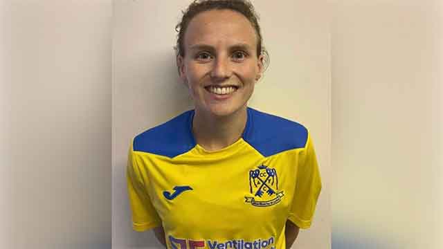 a female footballer in a yellow club shirt
