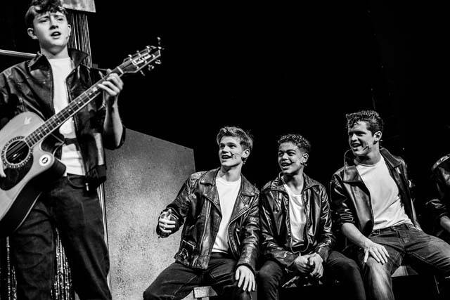 a teenage boy plays the guitart