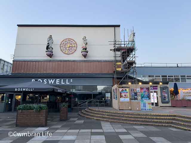 two statuettes on a. building overlooking a square