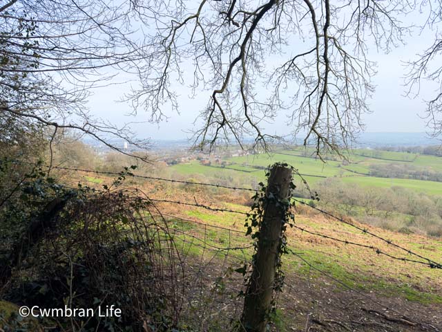 a view over a barbed wire fence across fields