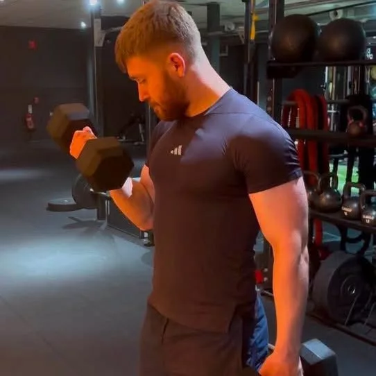 a man holding a dumbell in a gym