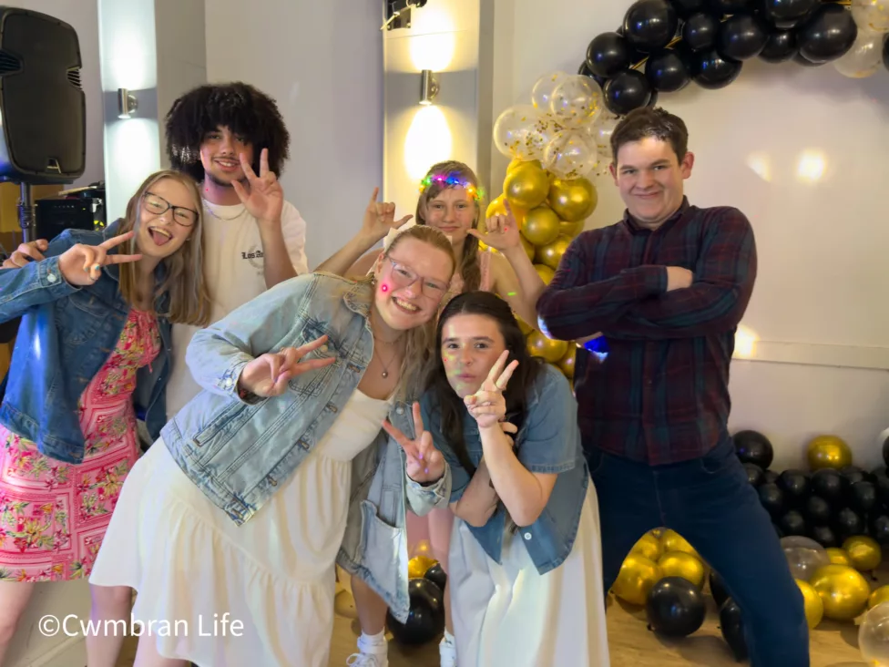 a group of students pose for a photo at their prom