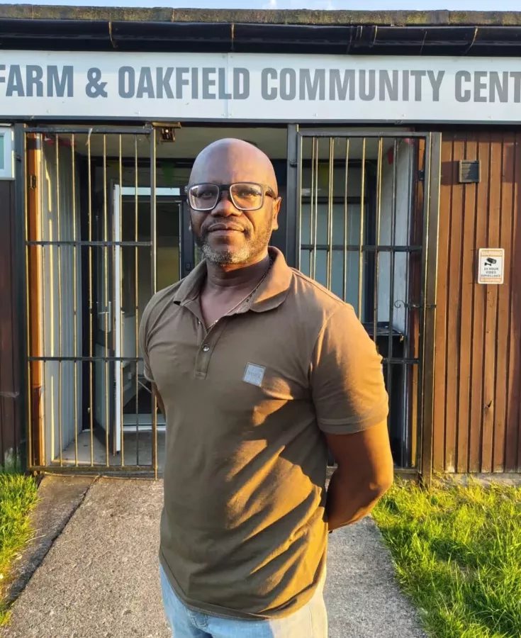 a man stood by the entrance to a community hall