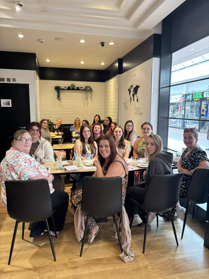 a group of people in a coffee shop sat at tables