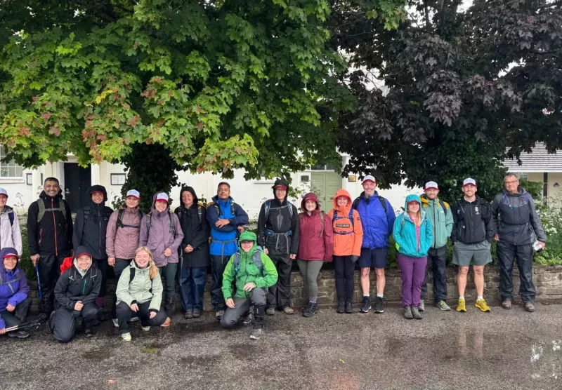 a group of men and women next to a tree