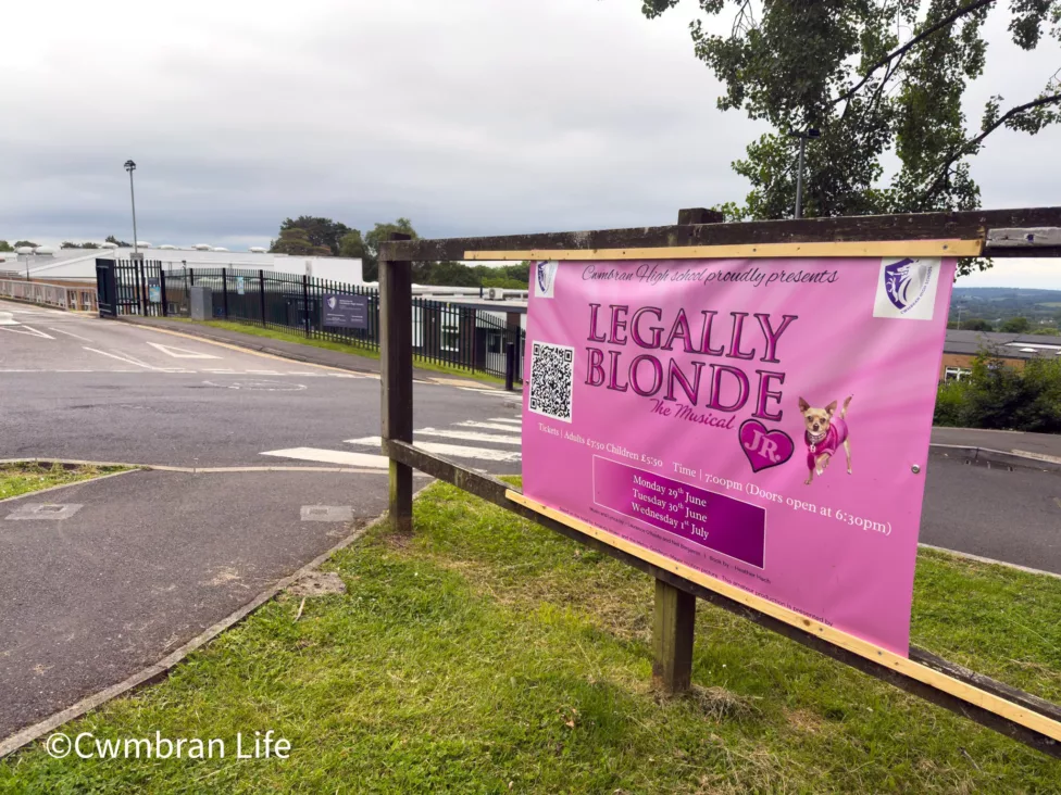 a banner on a fence for a legally blonde stage show