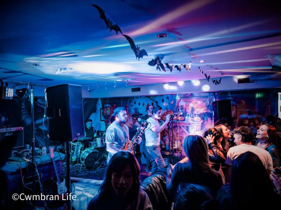 a band on stage sing to an audience