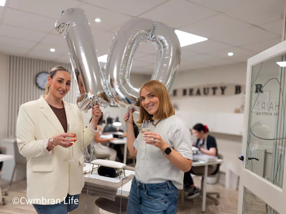 two women in a beauty bar stood in front of 'ten' ballon
