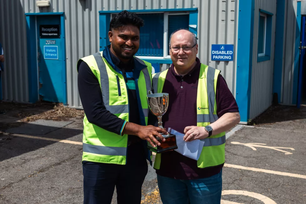 a man presents a trophy to another man