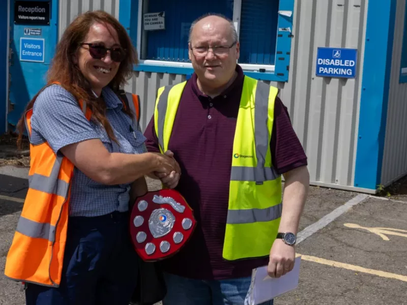 a man presents a trophy to a womman